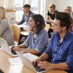 Mature Students Sitting At Desks In Adult Education Class